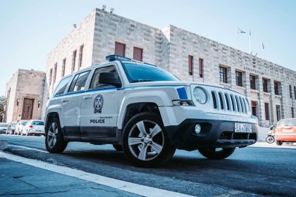 A Greek police car parked on a street in Rodos, Greece, showcasing local architecture.