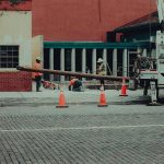 Street construction site with workers and equipment in an urban setting. Ideal for industry-themed projects.