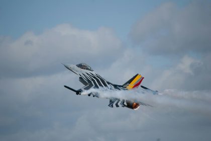 A dramatic airshow performance featuring a military jet with smoketrails in Fairford, UK.