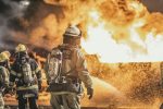 Courageous firefighters actively combat a massive fire, showcasing bravery and teamwork at night.
