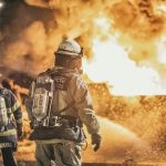Courageous firefighters actively combat a massive fire, showcasing bravery and teamwork at night.